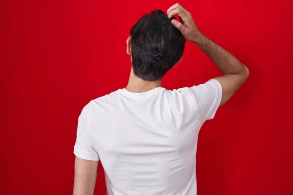 Young Hispanic Man Standing Red Background Backwards Thinking Doubt Hand — kuvapankkivalokuva