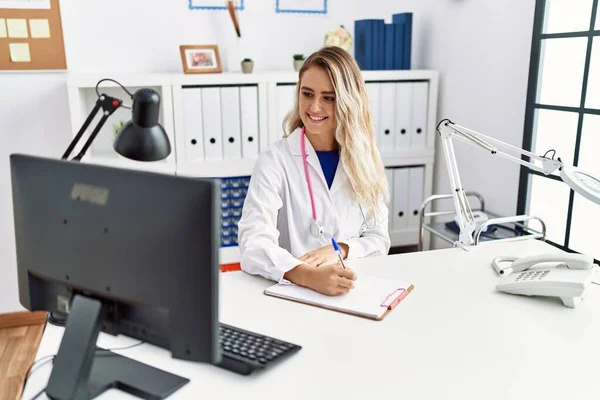Young Woman Wearing Doctor Uniform Writing Document Clinic — Stock fotografie
