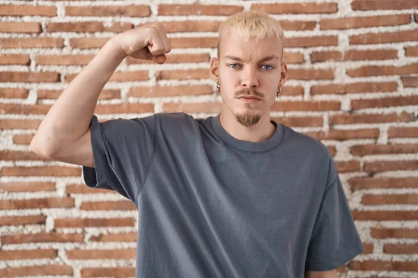 Jonge Blanke Man Staande Bakstenen Muur Sterke Persoon Tonen Arm — Stockfoto