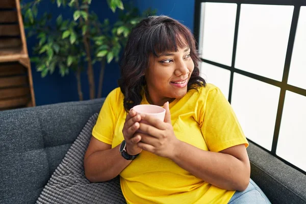 Junge Schöne Lateinische Frau Trinkt Kaffee Sitzend Auf Dem Sofa — Stockfoto