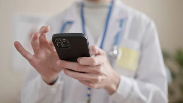 stock image Young hispanic man doctor using smartphone at clinic