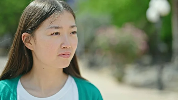 年轻的中国女人带着严肃的表情向旁边看去 — 图库照片