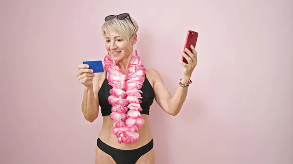 Блондинка Средних Лет Бикини Гавайских Леях Смартфоном Кредиткой Изолированном Розовом — стоковое фото