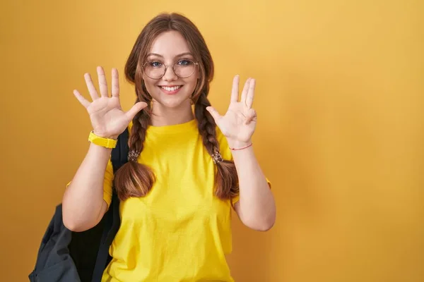 Jovem Caucasiana Usando Mochila Estudantil Sobre Fundo Amarelo Mostrando Apontando — Fotografia de Stock