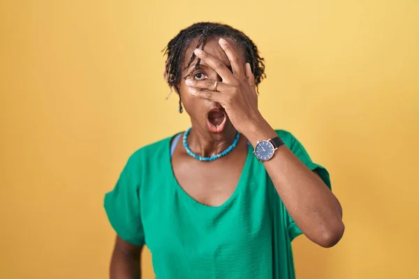 Mulher Africana Com Dreadlocks Sobre Fundo Amarelo Espreitando Choque Cobrindo — Fotografia de Stock