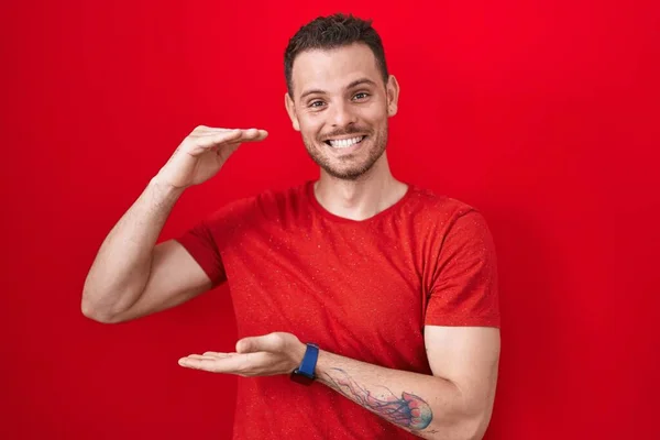 Homem Hispânico Jovem Sobre Fundo Vermelho Gesto Com Mãos Mostrando — Fotografia de Stock