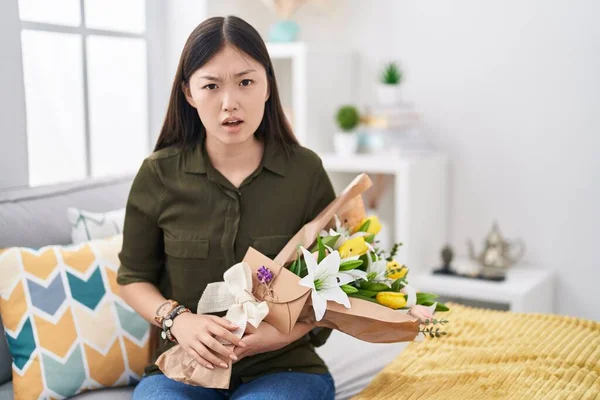 Chinês Jovem Segurando Buquê Flores Brancas Rosto Choque Olhando Cético — Fotografia de Stock