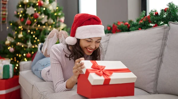 Young Beautiful Hispanic Woman Unpacking Gift Sitting Christmas Tree Home — Fotografia de Stock