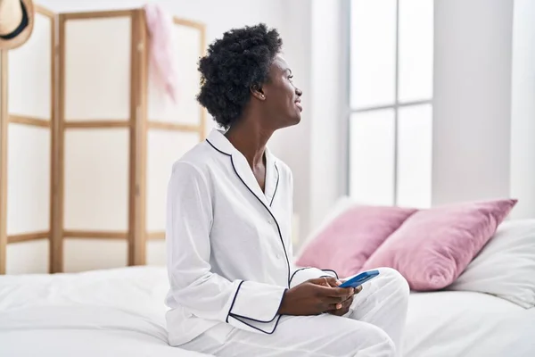 Young African American Woman Using Smartphone Sitting Bed Bedroom — Fotografia de Stock
