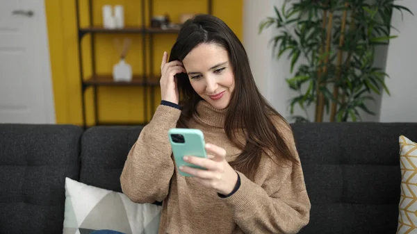 Evdeki Kanepede Oturan Güzel Spanyol Kadın Akıllı Telefon Kullanıyor — Stok fotoğraf