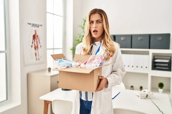 Young Blonde Doctor Woman Holding Box Medical Safety Items Clueless — Stock Photo, Image