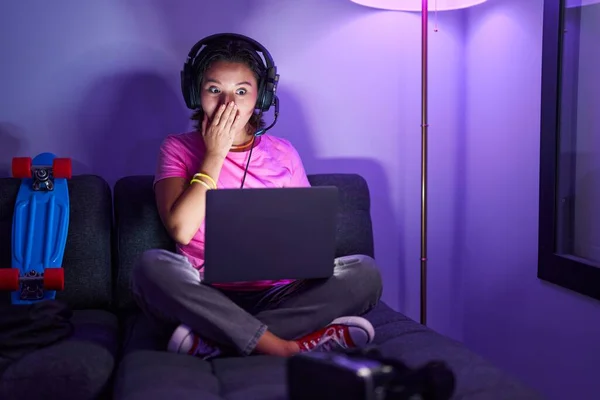 Jovem Hispânica Jogando Videogames Sentada Sofá Cobrindo Boca Com Mão — Fotografia de Stock