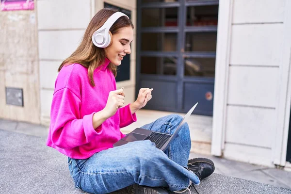 Junge Frau Sitzt Mit Laptop Und Kopfhörer Auf Bank Straße — Stockfoto