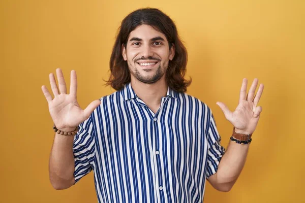 Латиноамериканец Длинными Волосами Стоит Желтом Фоне Показывает Пальцами Номер Девять — стоковое фото