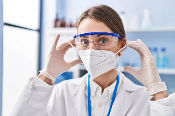 Νεαρή Καυκάσια Επιστήμονας Που Φοράει Ιατρική Μάσκα Στο Εργαστήριο — Φωτογραφία Αρχείου