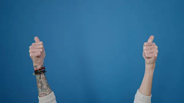 stock image Young hispanic man with thumbs up over isolated blue background