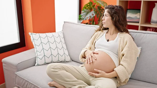 Jonge Zwangere Vrouw Zitten Bank Masseren Buik Thuis — Stockfoto