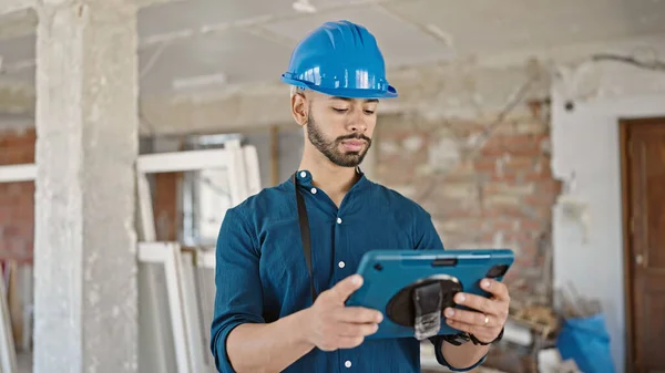 建筑工地用触摸板装置安装硬礼帽的年轻建筑师 — 图库照片