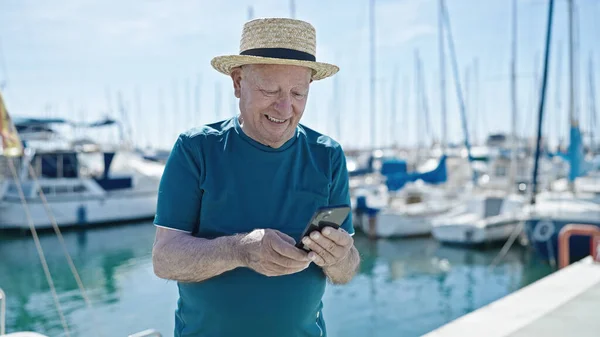 Senior Γκριζομάλλης Τουρίστας Φορώντας Καλοκαιρινό Καπέλο Χρησιμοποιώντας Smartphone Στο Λιμάνι — Φωτογραφία Αρχείου