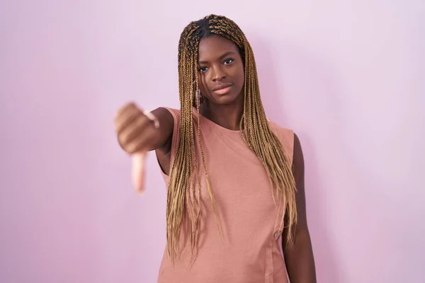 Африканская Американка Плетеными Волосами Стоящая Розовом Фоне Выглядящая Несчастной Злой — стоковое фото