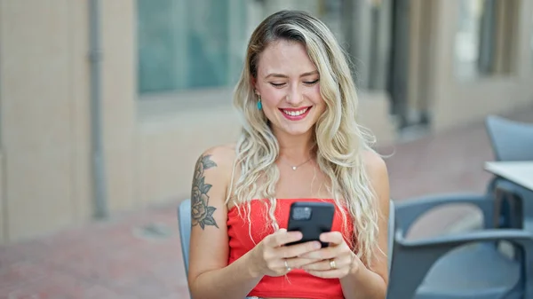 Νεαρή Ξανθιά Γυναίκα Που Χρησιμοποιεί Smartphone Χαμογελώντας Στη Βεράντα Καφετέρια — Φωτογραφία Αρχείου