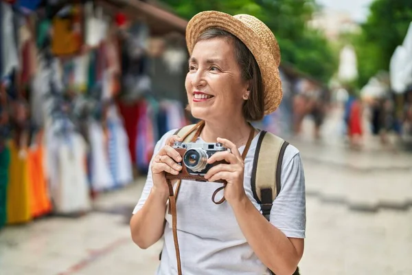 ストリートマーケットでヴィンテージカメラを使用した中世の女性観光客 — ストック写真