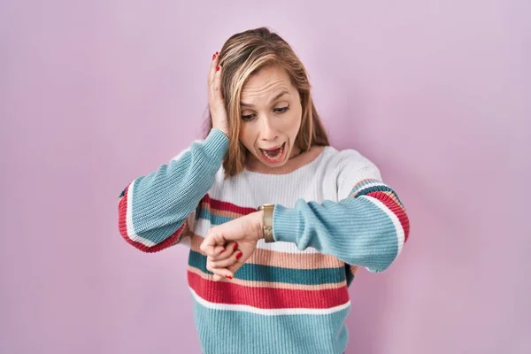 Young Blonde Woman Standing Pink Background Looking Watch Time Worried — Stock Photo, Image