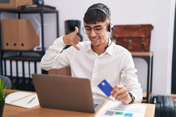 Joven Hombre Hispano Trabajando Usando Computadora Portátil Sosteniendo Tarjeta Crédito —  Fotos de Stock