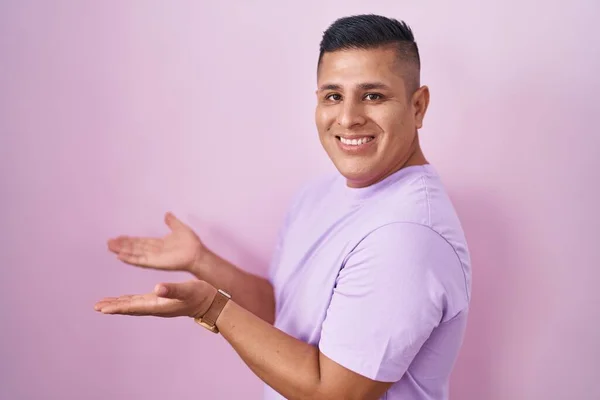 Young Hispanic Man Standing Pink Background Pointing Aside Hands Open — Stock Photo, Image