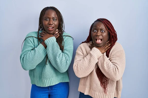 Two African Woman Standing Blue Background Shouting Suffocate Because Painful — Stock Photo, Image