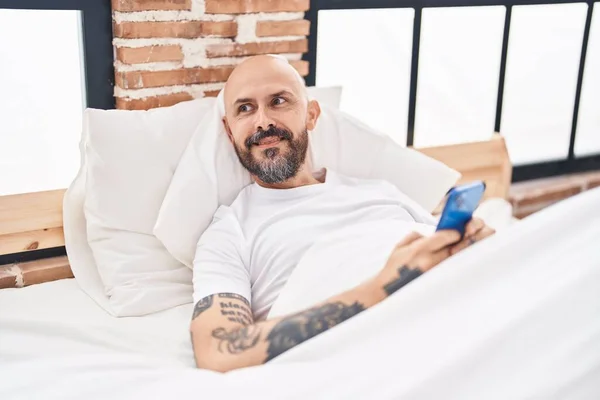 Ung Skallig Man Med Smartphone Liggande Sängen Sovrummet — Stockfoto