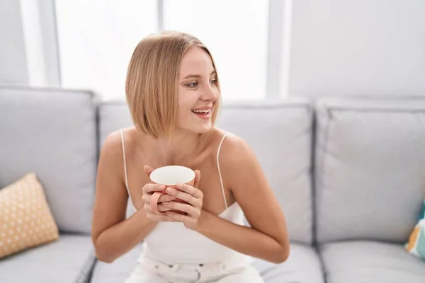 Young Blonde Woman Drinking Coffee Sitting Sofa Home — Stock Photo, Image