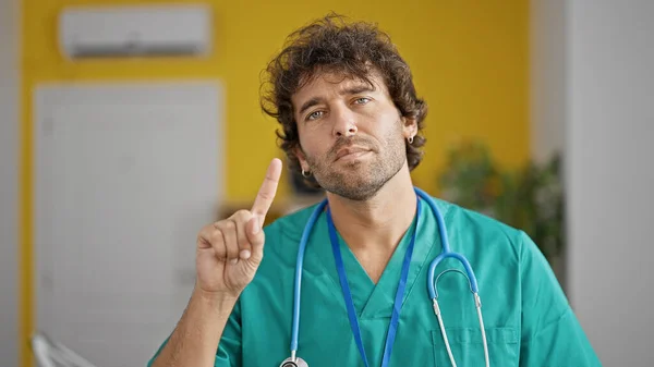 Young Hispanic Man Doctor Standing Serious Expression Saying Finger Clinic — Stock Photo, Image