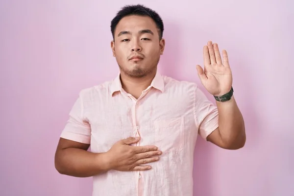 Китайский Молодой Человек Стоящий Розовом Фоне Ругаясь Рукой Груди Открытой — стоковое фото