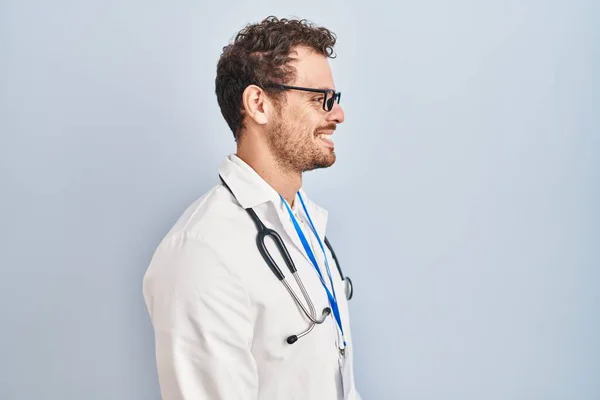 Ung Latinamerikansk Man Bär Läkare Uniform Och Stetoskop Tittar Sidan — Stockfoto