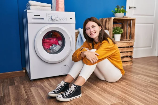 Çamaşır Odasında Sırıtan Çamaşır Makinesini Bekleyen Genç Sarışın Kadın — Stok fotoğraf