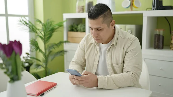 Joven Hombre Hispano Usando Smartphone Sentado Mesa Comedor —  Fotos de Stock