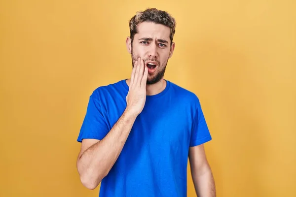 有胡子的西班牙裔男子站在黄色的背景上用手摸着嘴 因为牙齿疼痛或牙病而有痛苦的表情 — 图库照片