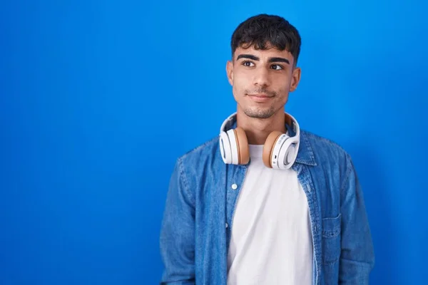 Young Hispanic Man Standing Blue Background Smiling Looking Side Staring — Stockfoto