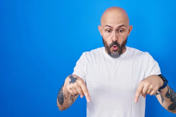Hispánec Tetováním Stojící Nad Modrým Pozadím Ukazuje Prstem Ukazujícím Reklamu — Stock fotografie