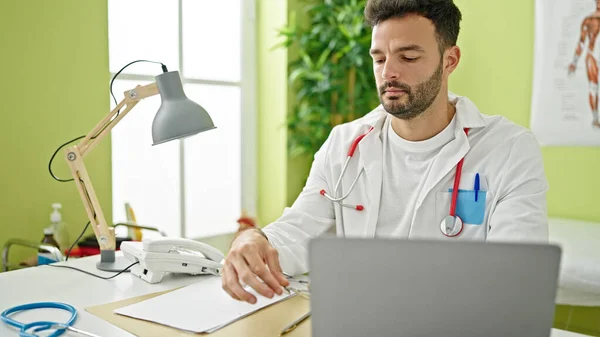 Young Hispanic Man Doctor Using Laptop Working Clinic — Stok fotoğraf