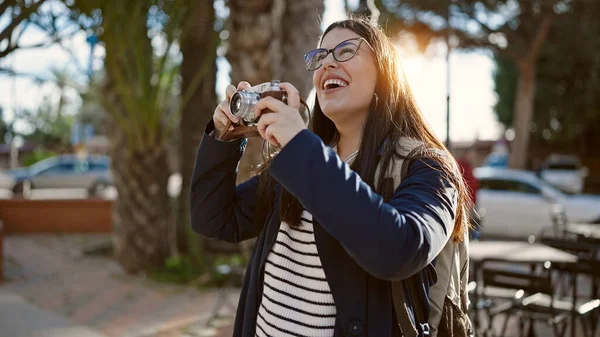 年轻的惊慌失措的女游客背着背包在街上用相机拍照 — 图库照片