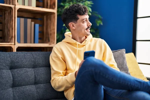 Young Caucasian Man Using Smartphone Sitting Sofa Home — Stockfoto