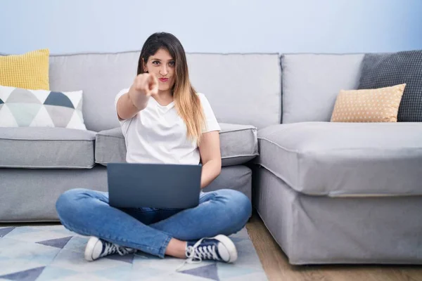 Genç Esmer Kadın Evde Oturmuş Dizüstü Bilgisayarını Kullanarak Kamerayı Işaret — Stok fotoğraf
