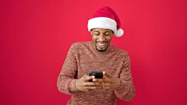 African American Man Wearing Christmas Hat Using Smartphone Smiling Isolated — Stock Photo, Image