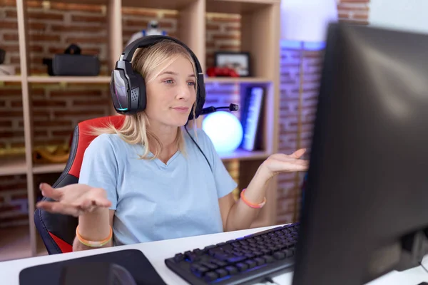 Junge Kaukasische Frau Spielt Videospiele Mit Kopfhörern Ahnungslos Und Verwirrt — Stockfoto