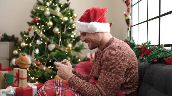 Jovem Caucasiano Usando Smartphone Sentado Sofá Pela Árvore Natal Casa — Fotografia de Stock