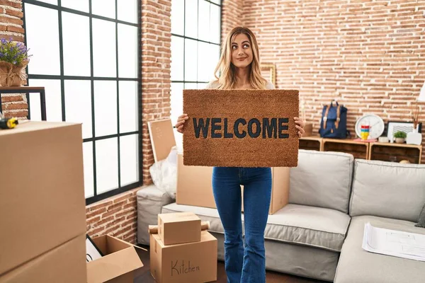 Young Blonde Woman Holding Welcome Doormat New Home Smiling Looking — Stock Photo, Image