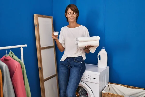 側に見て 離れて考えを見つめきれいな洗濯を保持ブルネット女性 — ストック写真