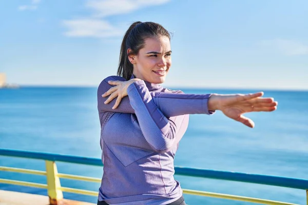 Ung Vacker Latinamerikansk Kvinna Bär Sportkläder Stretching Arm Vid Havet — Stockfoto